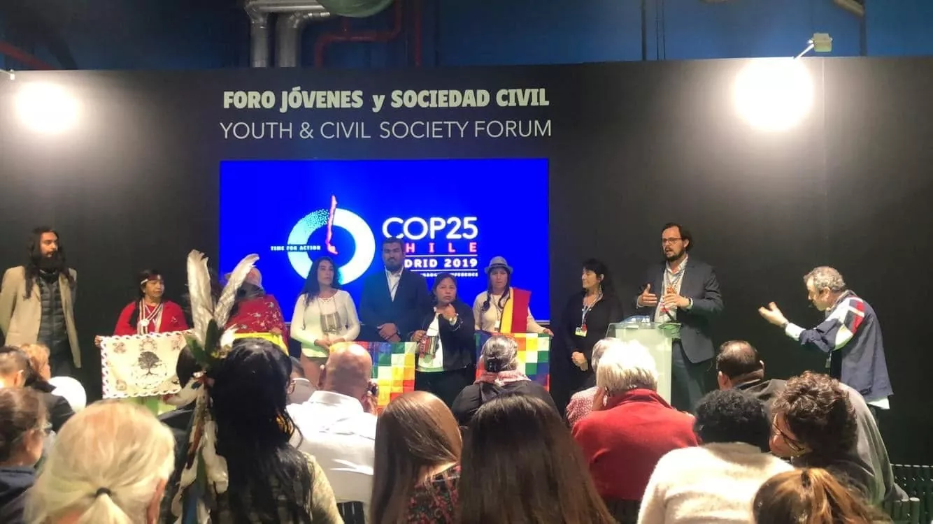 A group of speakers are gathered in front of an audience