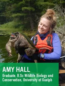 Une jeune femme dans un gilet de sauvetage tient une tortue de lac