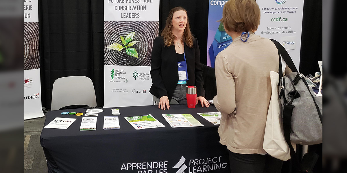 Tara parle avec une déléguée de la conférence au stand d'APLA Canada.