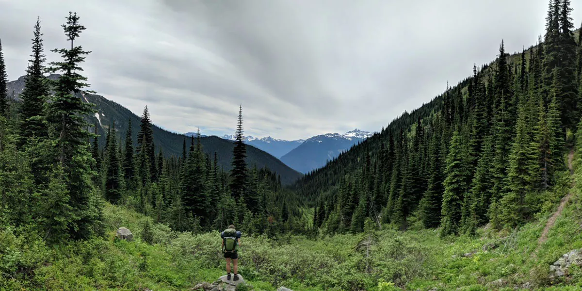 young woman looks out over a mountain range