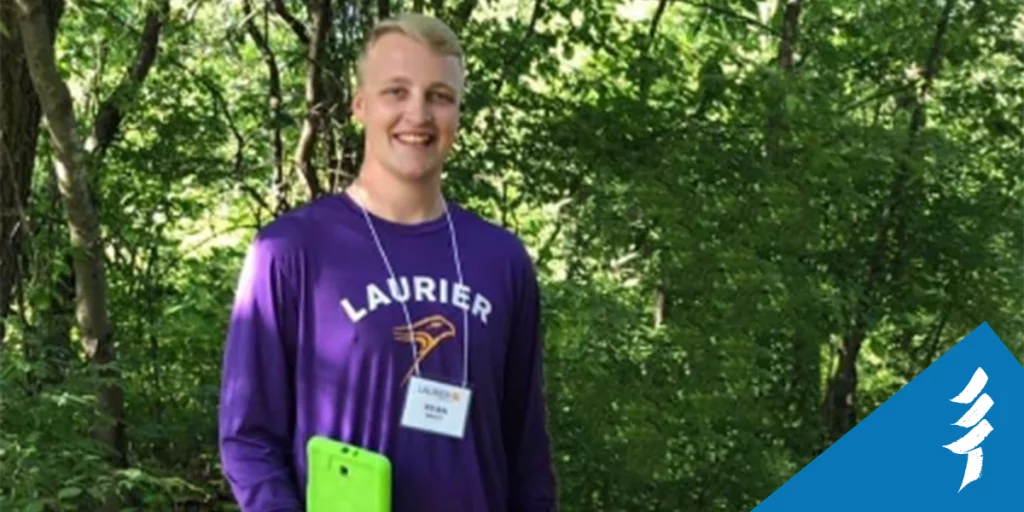 Photo of Ryan in a forest, holding a tablet