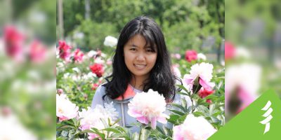 Shuya Huang sits in a field of flowers