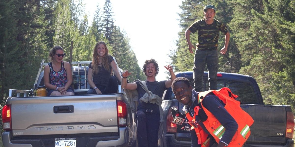 Youth hanging out in the forest with two pickup trucks