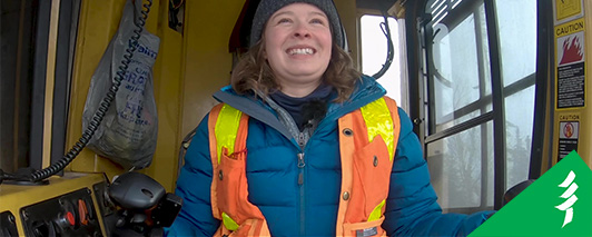 thumbnail of lacey driving a harvester