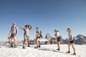 Five youth hikers with type one diabetes pose with their insulin pumps and flash/constant glucose monitors on Nub Peak of Mount Assiniboine Provincial Park.