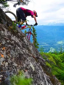 A young man biking down a mountain