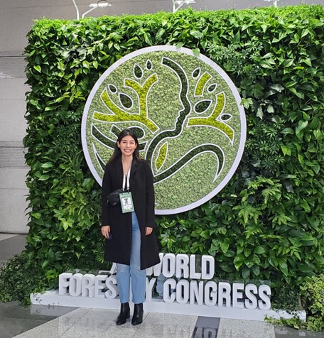 Maria standing in front of the World Forestry Congress sign