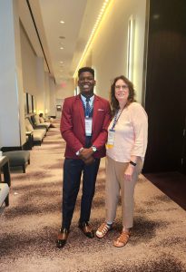 Mayowa standing next to his conference mentor, Ann Duff.