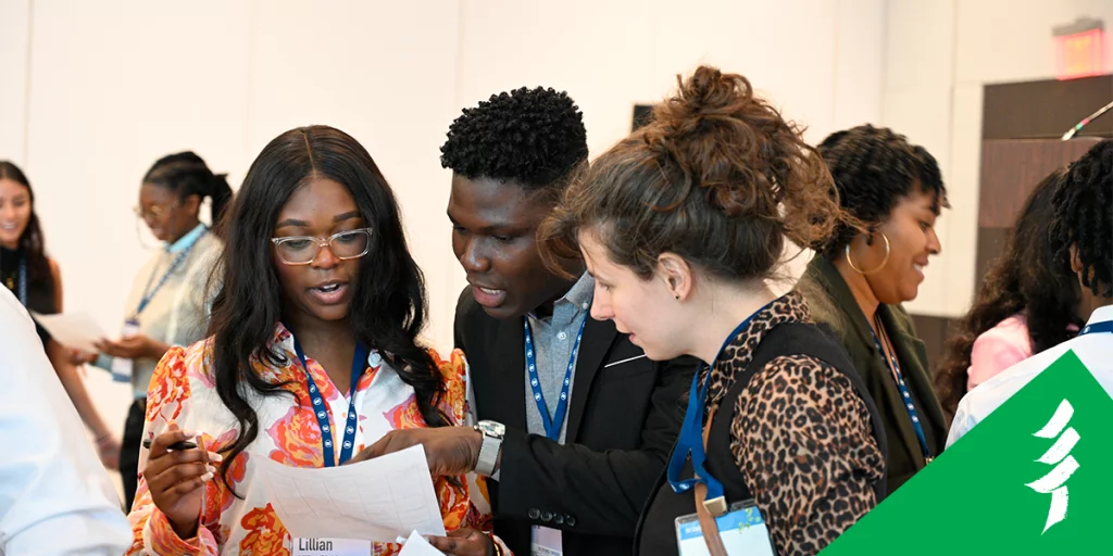 Mayowa networking with two attendees at the SFI Annual Conference.